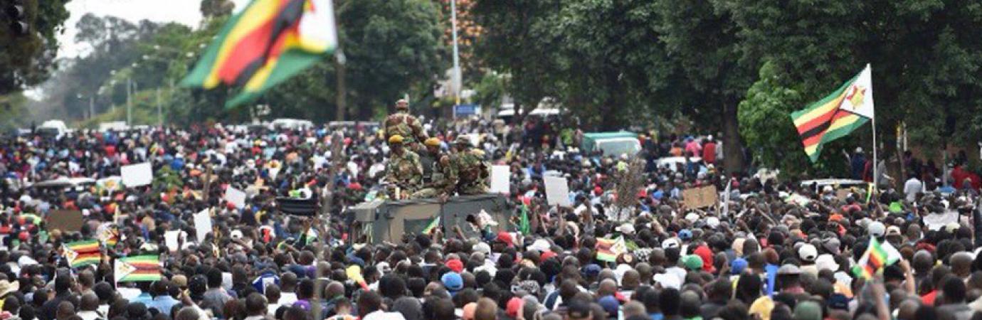 Zimbabweans celebrating next to a military tank in Harare, November 2017